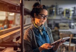 Femme dans son atelier qui regarde les annonces de vente d'entreprise